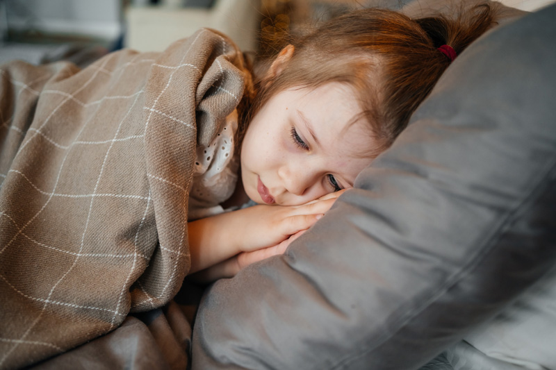 девочка с нарушением сна лежит на кровати